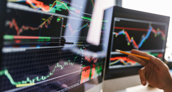 HandOfEuropeanBusinessmanWearingSuitSittingAtTableIn | Online Trading Secrets