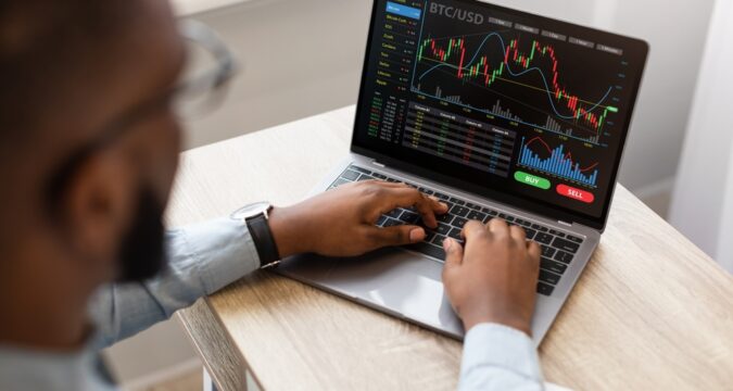 High-angleBackViewOfBlackBusinessmanUsingLaptopTypingOn | Online Trading Secrets Goldman Markets Review, gm-markets.com – Is Goldman Markets Scam Or A Recommended Trading Platform?